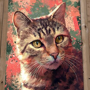 May include: A close-up portrait of a tabby cat with green eyes. The cat is looking directly at the viewer. The background is a colorful abstract design with splashes of red, orange, and green.