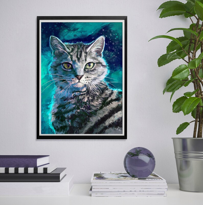 以下が含まれることがあります： 緑色の目を持ち、グレーの縞模様の猫の額装アートプリント。猫はティールとネイビーブルーの背景に描かれています。アートワークは黒いフレームに入っており、白い壁に飾られています。これは、家庭の猫の肖像画です。