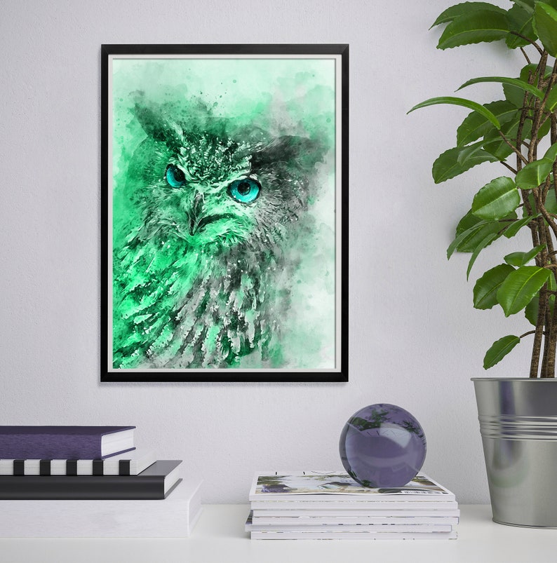 May include: A watercolour painting of an owl with bright blue eyes. The owl is rendered in shades of green and white, with a soft, ethereal background.