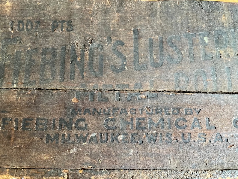 May include: Close-up of a wooden box with black lettering. The box is labeled "Fiebing's Luster" and "Manufactured by Fiebing Chemical Co. Milwaukee Wis. U.S.A."
