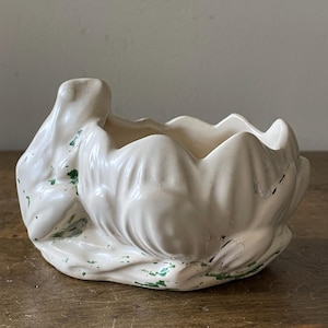 May include: White ceramic planter shaped like a flower with green painted accents.