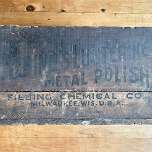 May include: A vintage wooden box with black lettering that reads "Fiebing's Lusterine Metal Polish" and "Fiebing Chemical Co. Milwaukee, Wis. U.S.A."