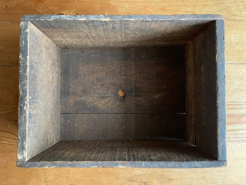 May include: A wooden box with a dark brown stain. The box is empty and has a small hole in the bottom.