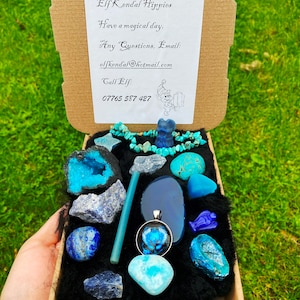 Può includere: Una piccola scatola di cartone piena di pietre preziose blu e turchesi, cristalli e un ciondolo con un design di uccello blu. La scatola è foderata con feltro nero e ha una nota sulla parte superiore che dice "Grazie dagli Elfi Kendal Hippies Buona giornata magica, Domande? Email: elfkendal@hotmail.com Chiama l'Elfo: 07765 587 427"