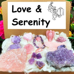 May include: A box filled with pink and purple crystals, including amethyst, rose quartz, and selenite. The box is labelled "Love & Serenity".