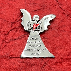 May include: Silver angel charm with a red heart and the text "Guardian Angel" and "Never drive faster than your Guardian Angel can fly!"