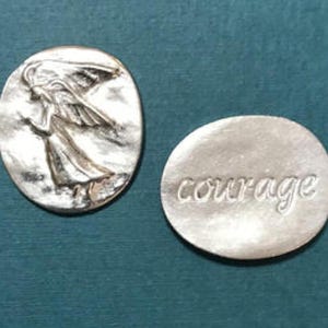 Oval pewter token with angel embossed on token with bright silver finish on one side with the word courage engraved on the back.