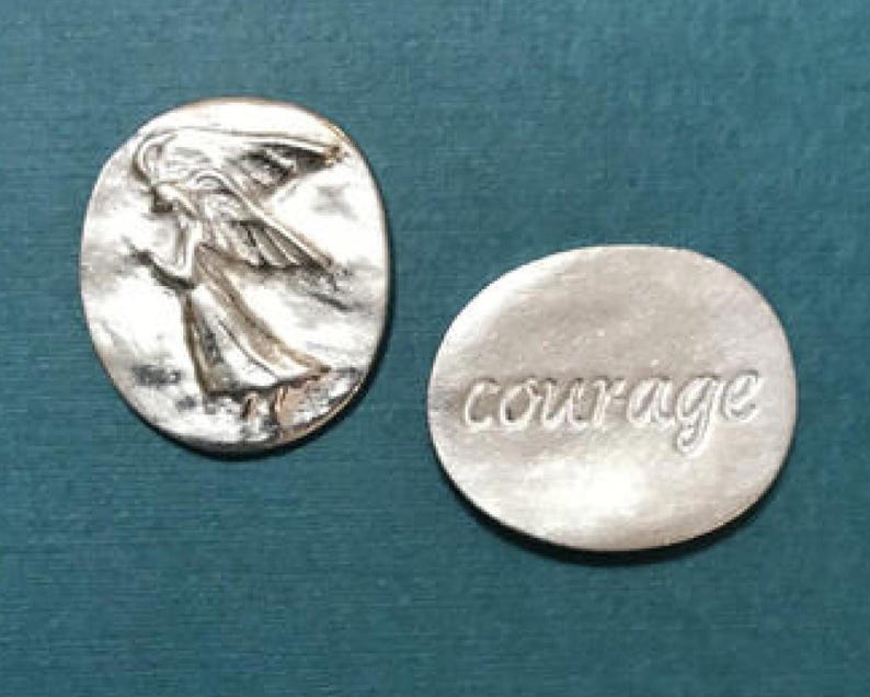 Oval pewter token with angel embossed on token with bright silver finish on one side with the word courage engraved on the back.