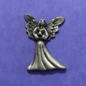 May include: A silver angel figurine with wings outstretched and a flowing gown. The angel is holding a heart in its hands.
