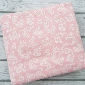 May include: Pink fabric with a white paisley pattern.