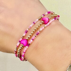 14k gold filled, pink, hot pink, seed bead bracelets with heart accents. Great for stacking.