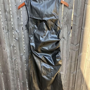 May include: A black sleeveless faux leather dress with a mock neck and a fitted silhouette.