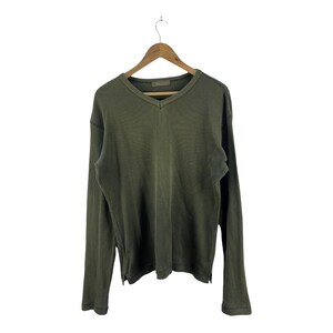 May include: A long-sleeved, dark green v-neck sweater with a ribbed texture.