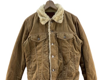 May include: A brown corduroy jacket with a faux fur collar. The jacket has a button closure and two front pockets.
