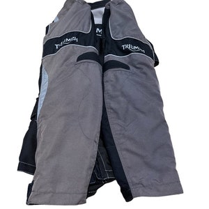 Puede incluir: Chaqueta de moto negra y gris con la palabra "Triumph" impresa en las mangas.