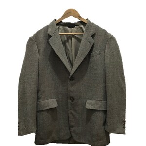 以下が含まれることがあります： 木製のハンガーにかけられた、薄いチェック柄のグレーのブレザー。ブレザーは3つボタン留め、フラップポケットが2つ付いている。