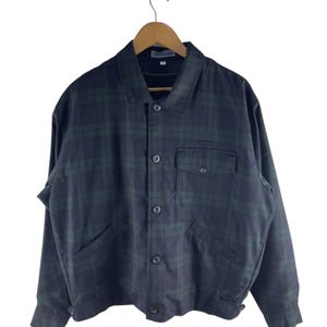 May include: A dark blue and green plaid jacket with a button-up front, two chest pockets, and two side pockets. The jacket is hanging on a wooden hanger against a white background. The jacket has a collar and long sleeves.