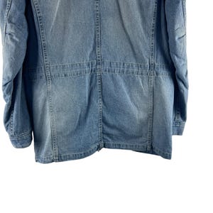 Puede incluir: Una taza de cer&aacute;mica blanca con un asa negra y el texto "But First, Coffee" en negrita negra. La taza se encuentra sobre un fondo borroso, sugiriendo un ambiente acogedor.