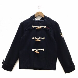 May include: A navy blue hooded duffle coat with white rope toggles and wooden buttons. The coat has a patch on the right sleeve with an eagle design.