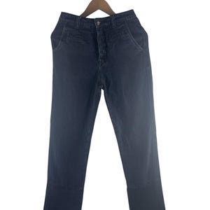 May include: Dark wash denim jeans hanging on a wooden hanger. The jeans have a button closure, front pockets, and a straight leg design. The denim appears to be a solid, dark blue color.