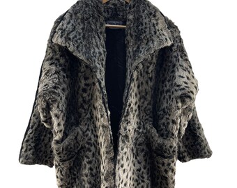 May include: A gray and black leopard print faux fur coat with a black zipper and two pockets. The coat is hanging on a wooden hanger.