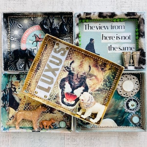 Op de afbeelding: Een verzameling decoratieve dozen met verschillende thema's. Eén doos bevat een leeuwenafbeelding met het woord "LUXUS". Andere dozen bevatten dierenbeeldjes, tekst en decoratieve elementen. De dozen hebben gouden en patroonaccenten.