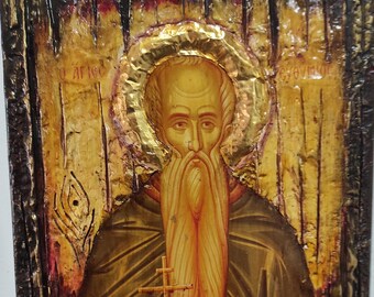 May include: A hand-painted icon of a bearded man holding a cross and a scroll. The icon is on a wooden background with gold leaf accents. The text "Ο άγιος" and "Θεοδωρος" are visible in the top corners.