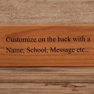 May include: A wooden block with the text "Customize on the back with a Name, School, Message etc..." engraved on it.