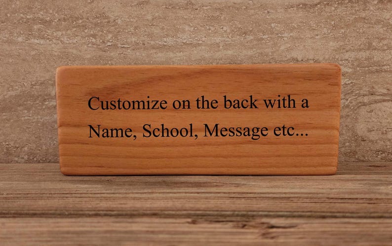 May include: A wooden block with the text "Customize on the back with a Name, School, Message etc..." engraved on it.