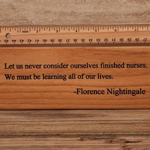 May include: A wooden plaque with a quote from Florence Nightingale that reads: "Let us never consider ourselves finished nurses. We must be learning all of our lives."