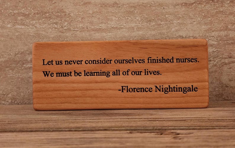 May include: Wooden plaque with a quote by Florence Nightingale: "Let us never consider ourselves finished nurses. We must be learning all of our lives."