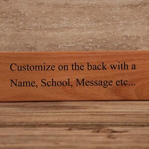 May include: A wooden sign with the text "Customize on the back with a Name, School, Message etc..." engraved on it.