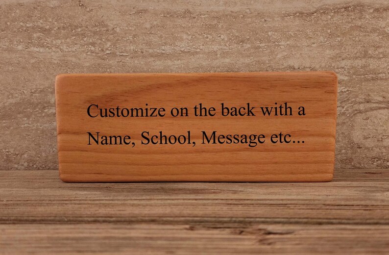 May include: A wooden sign with the text "Customize on the back with a Name, School, Message etc..." engraved on it.