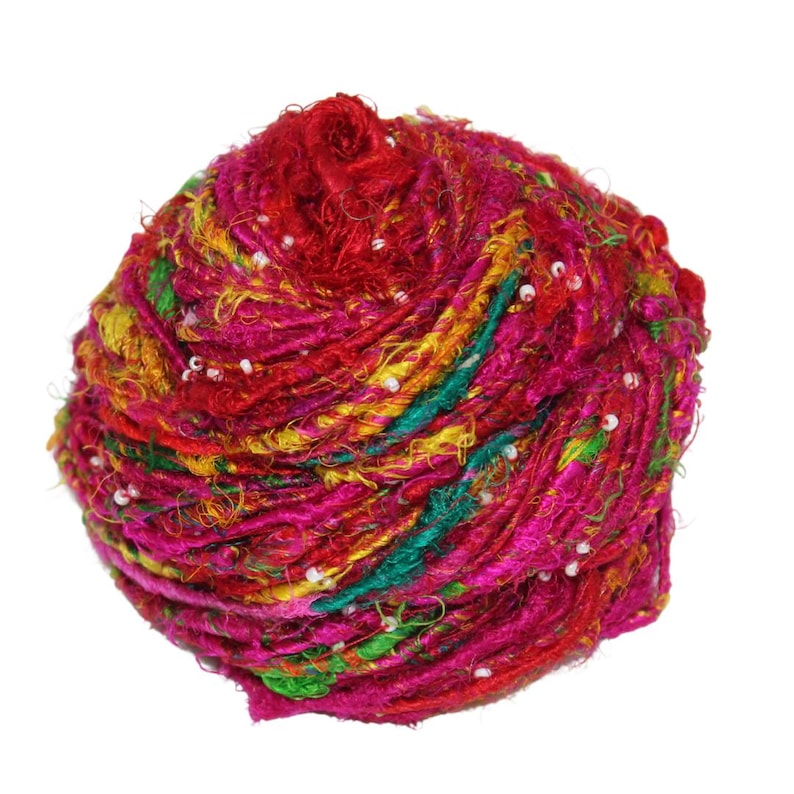 May include: A ball of colorful silk yarn with white beads woven throughout. The yarn is a mix of pink, red, yellow, green, and orange.