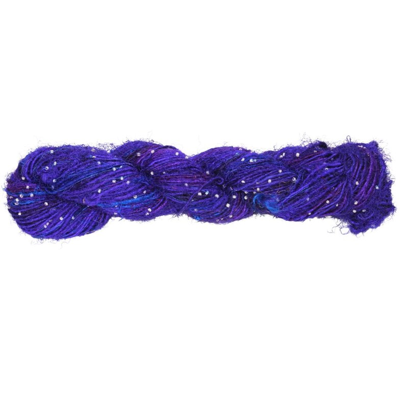 May include: A skein of purple and blue yarn with white beads woven throughout.