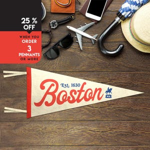 May include: A triangular felt pennant featuring the word Boston in large red script, the text Est. 1630 in blue, and a small blue icon of a person on a horse with the letters MA below it. The pennant has a red vertical strip and two white ties.
