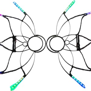 Pode incluir: Um par de asas de metal preto com luzes LED coloridas. As asas são projetadas para serem usadas nas costas e têm uma forma circular no centro.