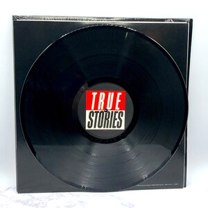 Puede incluir: Disco de vinilo negro con una etiqueta roja y blanca que dice "TRUE STORIES".