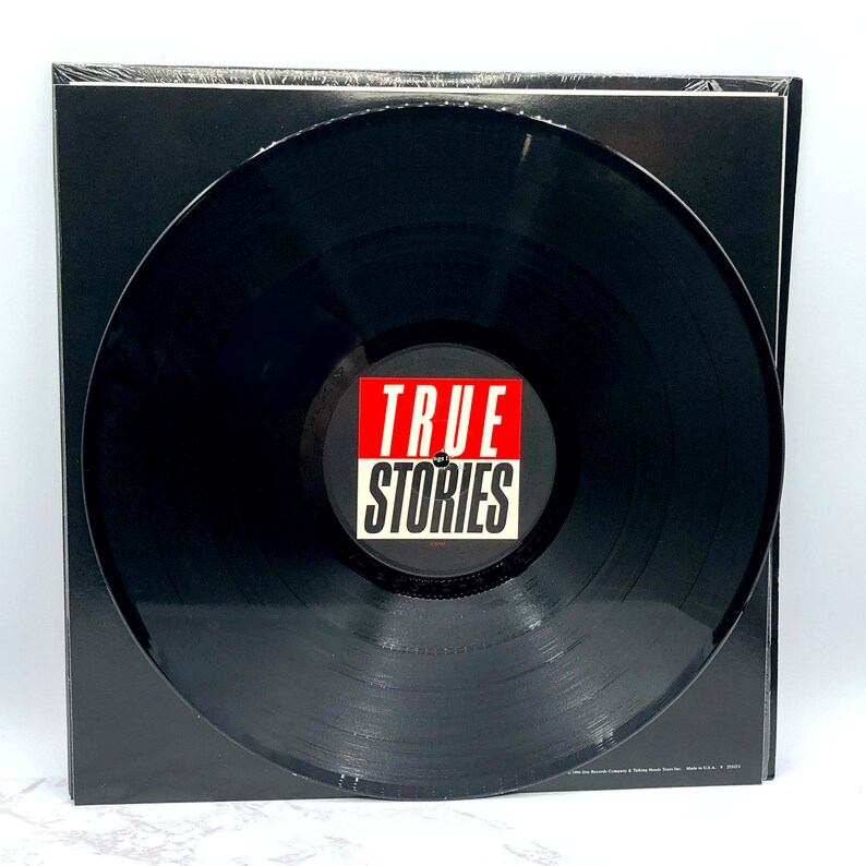 Puede incluir: Disco de vinilo negro con una etiqueta roja y blanca que dice "TRUE STORIES".