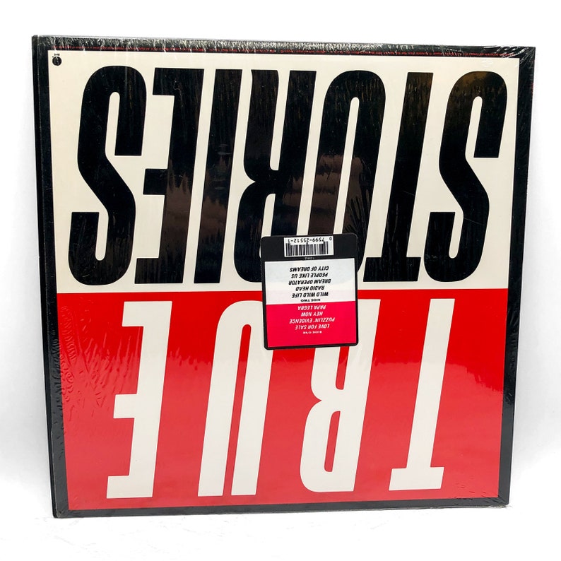 Puede incluir: Un &aacute;lbum de vinilo negro y rojo con el t&iacute;tulo "TRUE STORIES" impreso en blanco. La portada del &aacute;lbum presenta el t&iacute;tulo en letras grandes y en negrita.