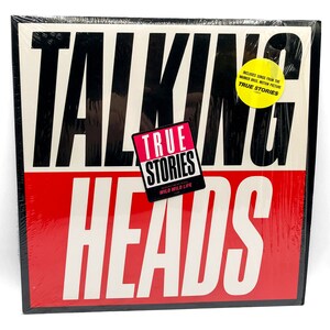 Puede incluir: Una portada de &aacute;lbum de vinilo negro y rojo con el texto "Talking Heads" en letras blancas. El &aacute;lbum se titula "True Stories" e incluye canciones de la pel&iacute;cula de Warner Bros. "True Stories".