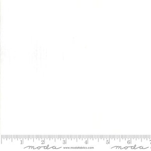 May include: A white fabric with a ruler along the bottom edge. The ruler is marked with inch increments. The fabric has a subtle texture and is suitable for quilting and sewing projects. The brand name "moda" is printed on the ruler.