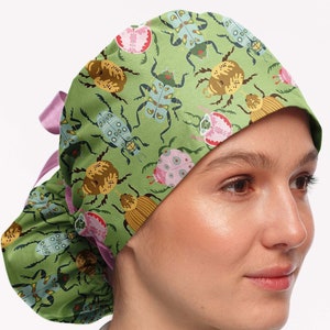 May include: A green surgical scrub hat with a pink tie and a colorful beetle pattern.