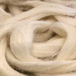 May include: A close-up of a pile of white, fluffy cotton fibers. The fibers are soft and delicate, and they are perfect for crafting or filling pillows.