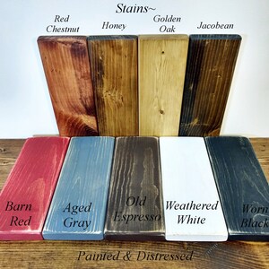 May include: Wood stain colour chart displaying 10 different stain colours. The top row shows Red Chestnut, Honey, Golden Oak, and Jacobean. The bottom row shows Barn Red, Aged Grey, Old Espresso, Weathered White, and Worn Black. The text "Stains~" and "Painted & Distressed" are also visible.