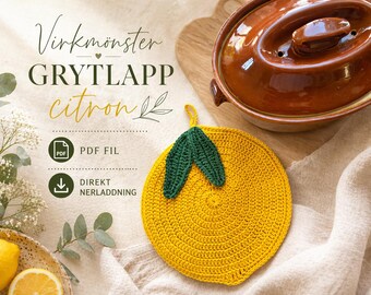 Puede incluir: Un salvamanteles amarillo tejido a ganchillo con forma de limón y hojas verdes. Está sobre una superficie beige, junto a una olla de cerámica marrón y una tabla de madera. El texto dice "Virkmönster GRYTLAPP citron".