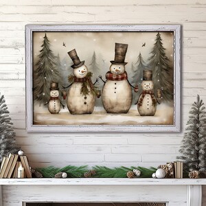 Op de afbeelding: Een schilderij van een familie sneeuwpoppen die in een besneeuwd bos staan. De sneeuwpoppen dragen hoeden en sjaals en houden mokken vast. De achtergrond is lichtbruin met een wit sneeuweffect.