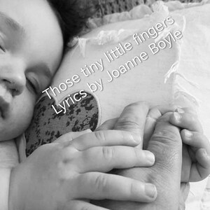 Puede incluir: Imagen en blanco y negro de un bebé durmiendo, agarrando la mano de un adulto. El texto "Those tiny little fingers Lyrics by Joanne Boyle" es visible en la imagen.