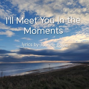 Może przedstawiać: Krajobraz nadmorski z tekstem "I'll Meet You In the Moments" i "lyrics by Joanne Boyle" na tle dramatycznego nieba. Obraz przedstawia plażę, morze i trawiaste wydmy pod zachmurzonym niebem.