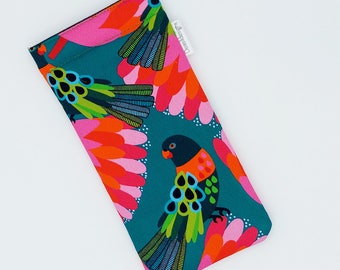 May include: A teal blue glasses case with a colorful parrot print. The parrots are black, red, orange, pink, green, and blue. The case has a white label that says "Daisy's Eyes".